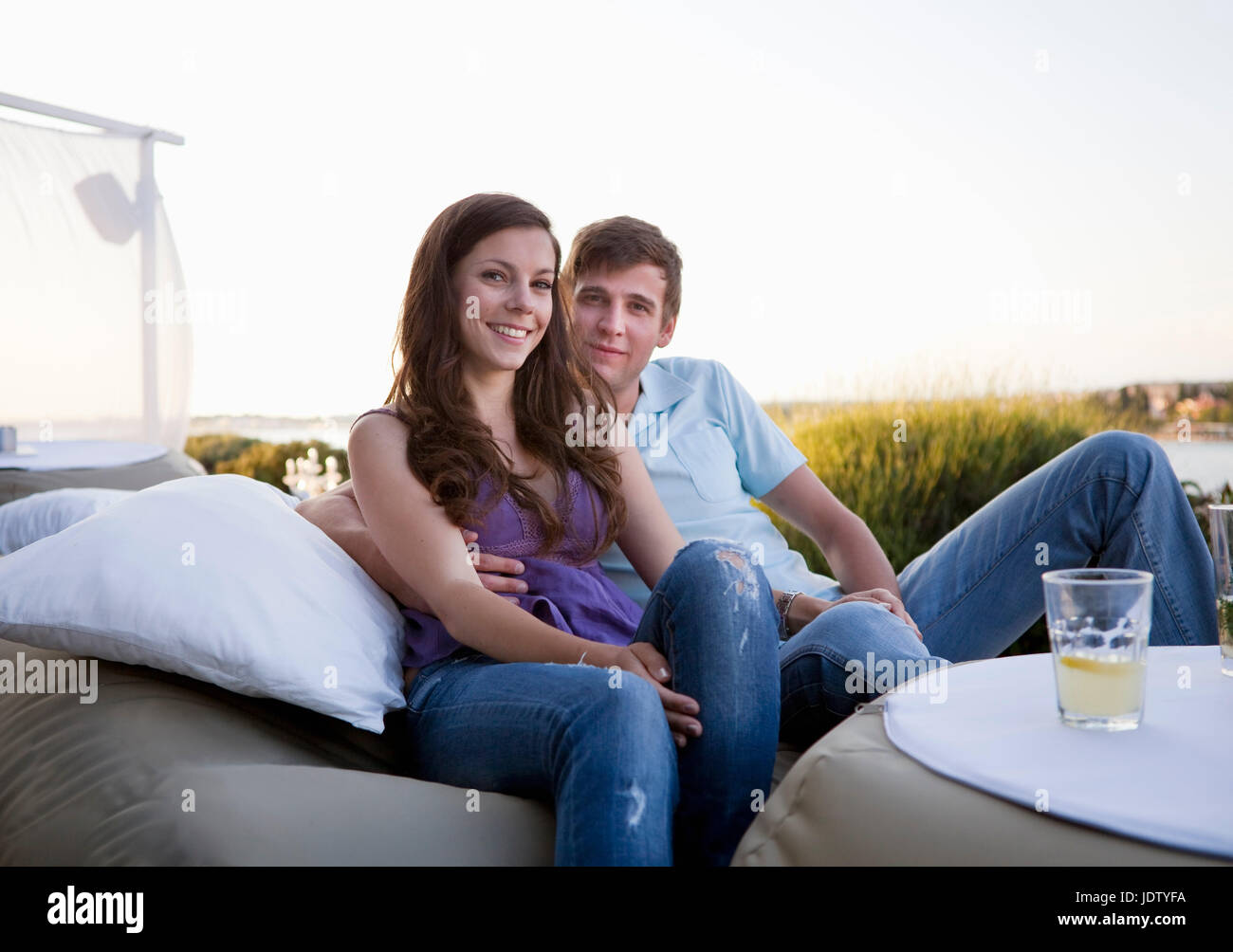 Couple relaxing on couch outdoors Stock Photo