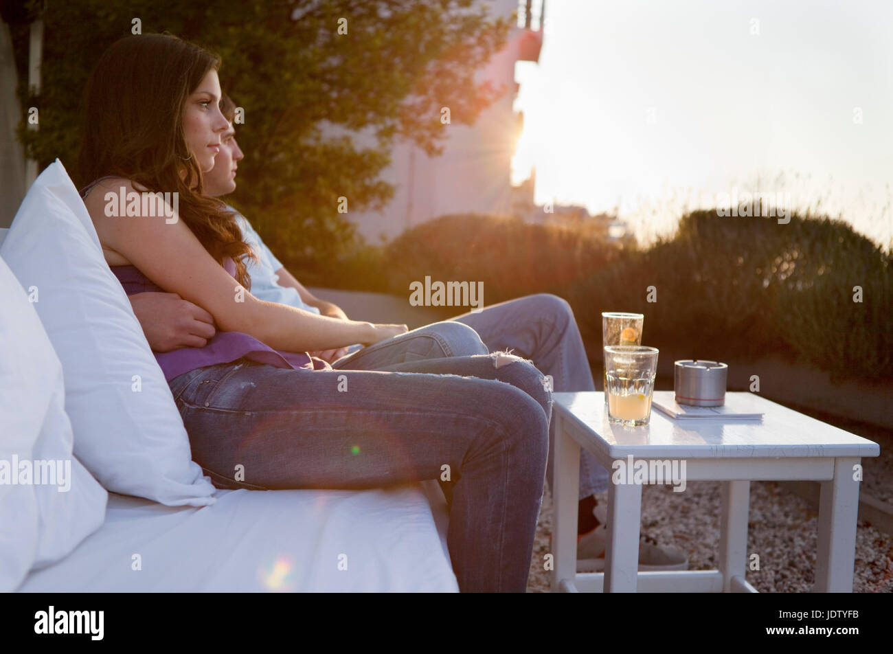 Couple relaxing on couch outdoors Stock Photo
