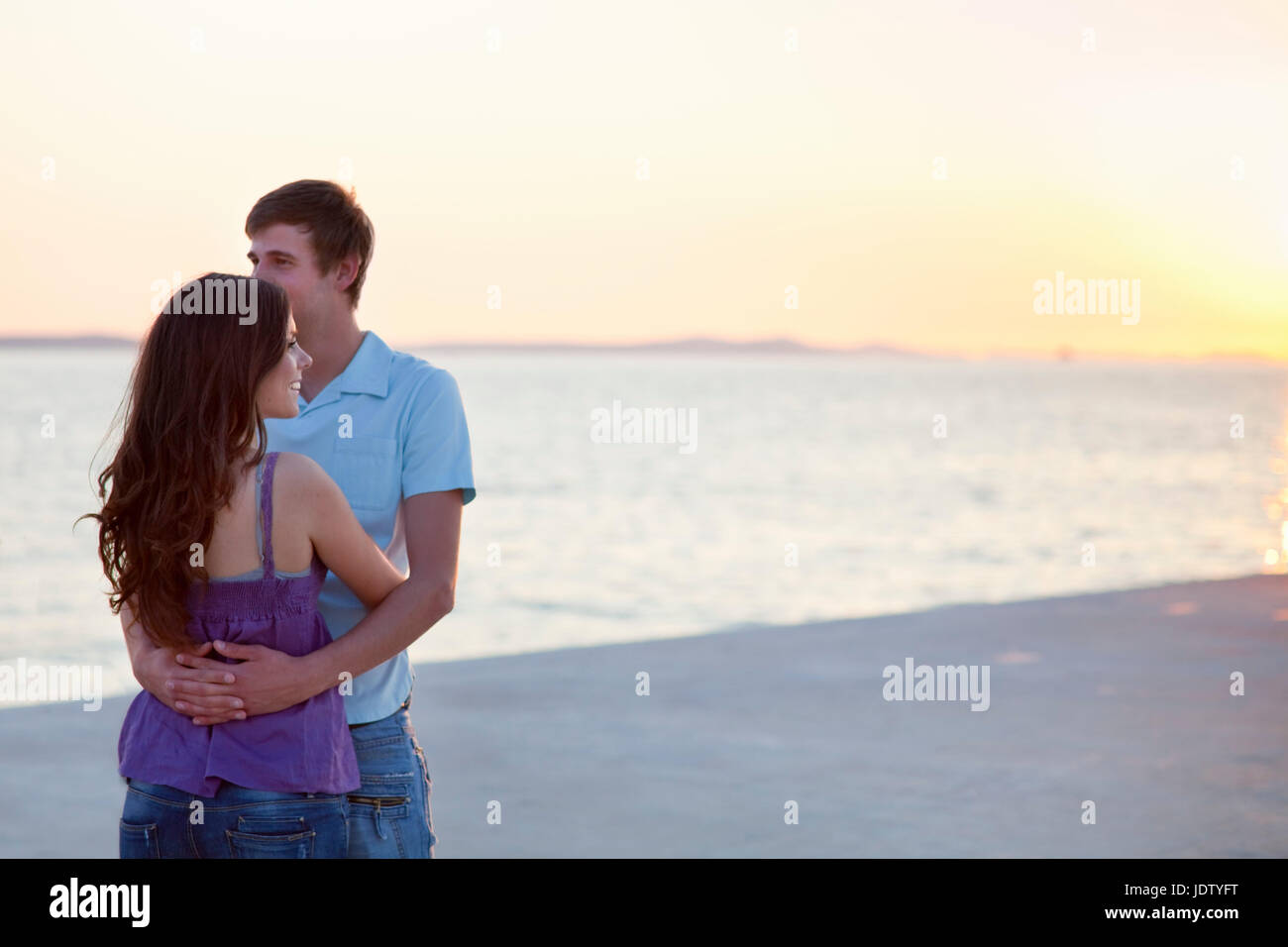 Couple hugging on pier outdoors Stock Photo