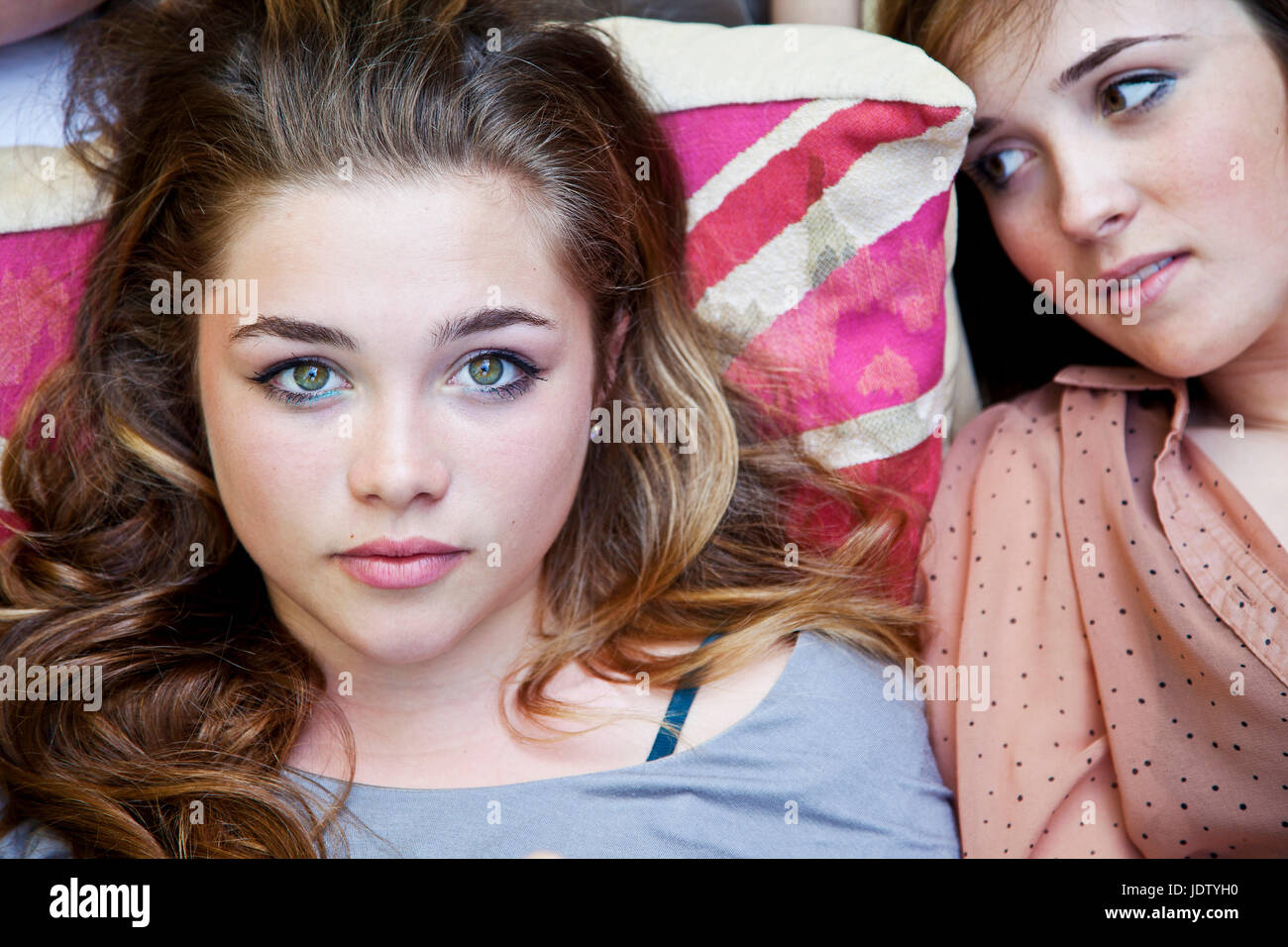 Teenage girls laying on bed Stock Photo