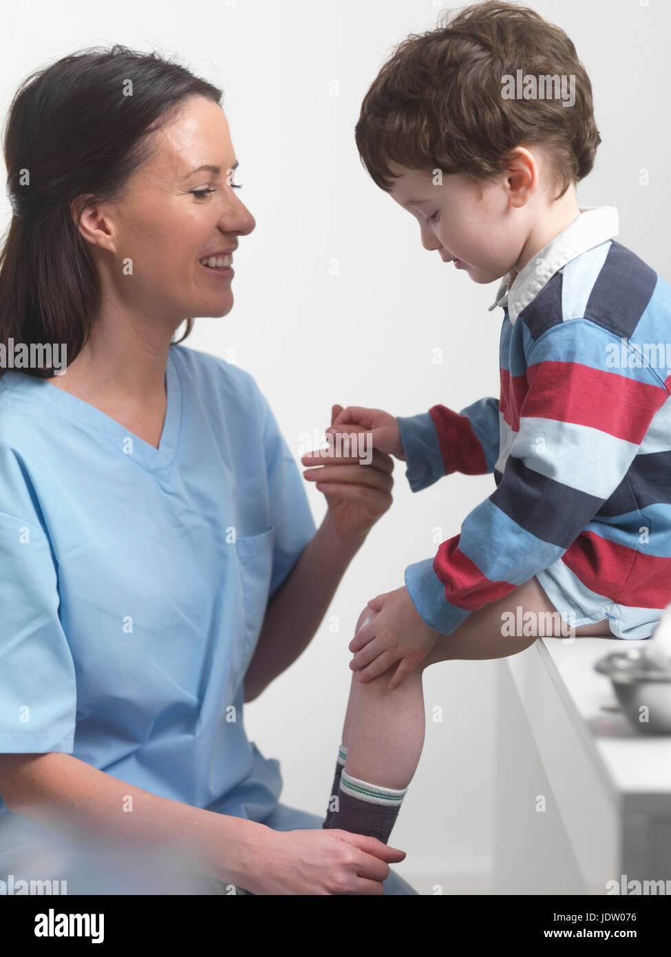 Nurse talking to boy in doctors office Stock Photo