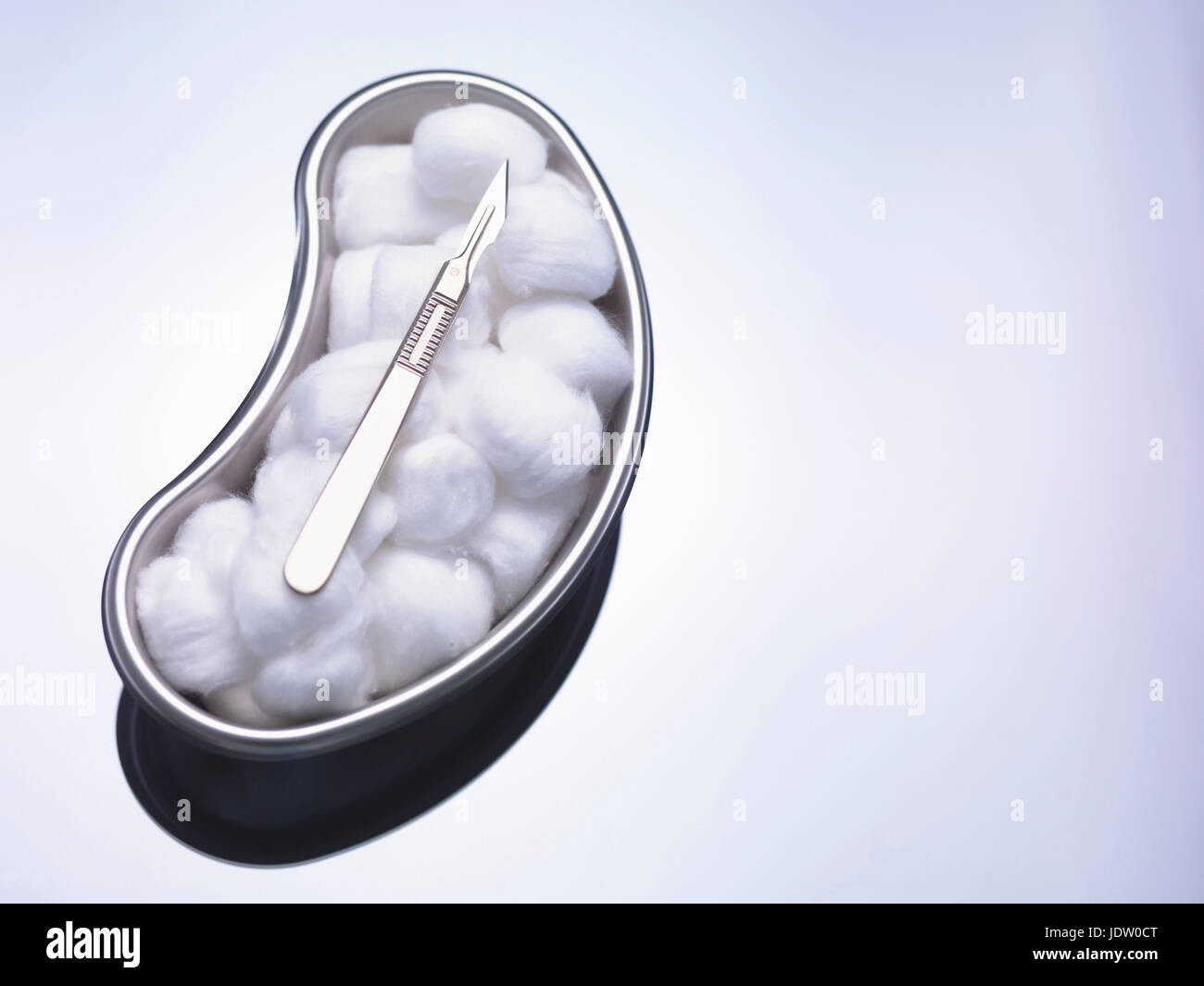 Cotton balls and scalpel in kidney bowl Stock Photo