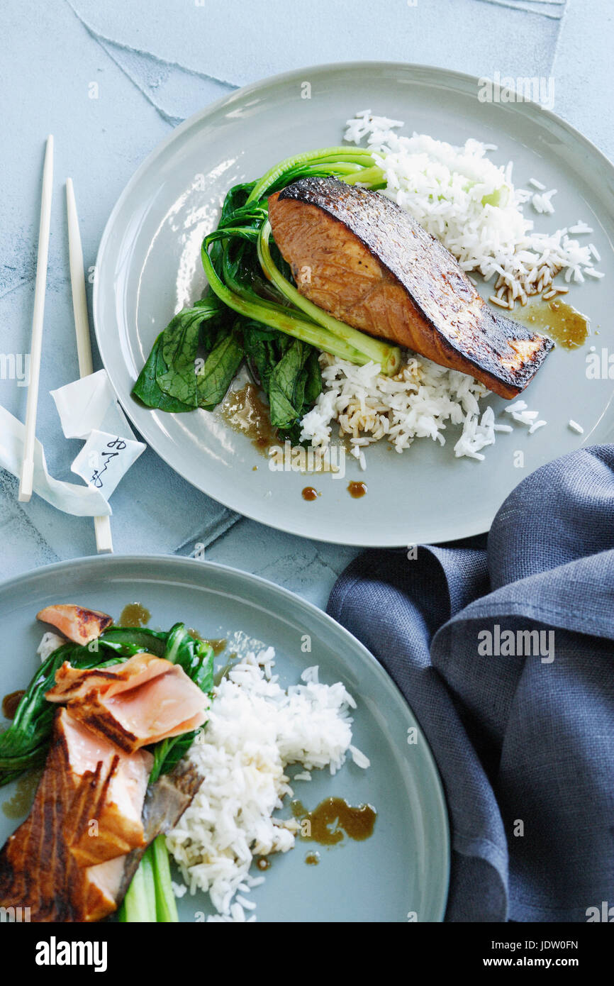 Plates of fish, rice and greens Stock Photo
