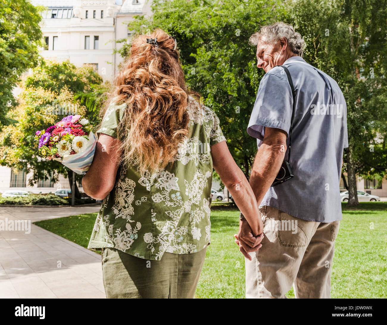 Older couple holding hands in park Stock Photo