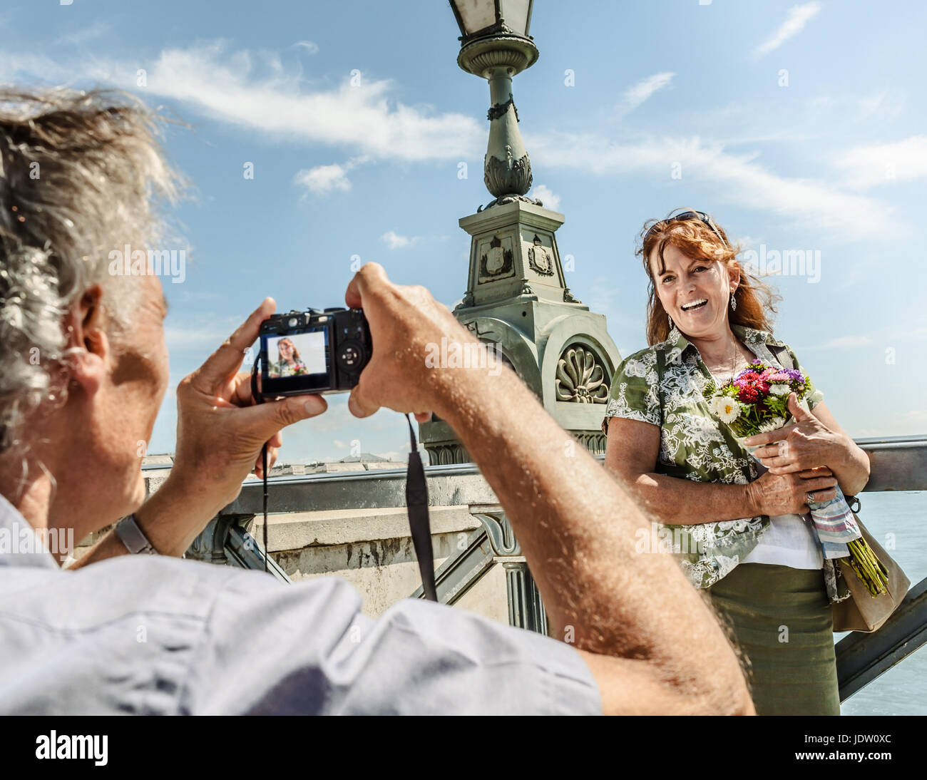 Older man taking picture of wife Stock Photo