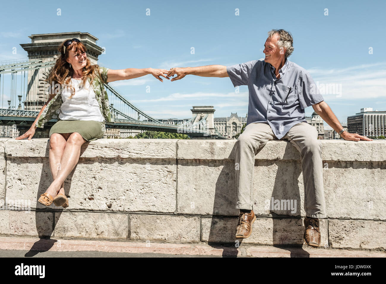 Older couple holding hands on bridge Stock Photo