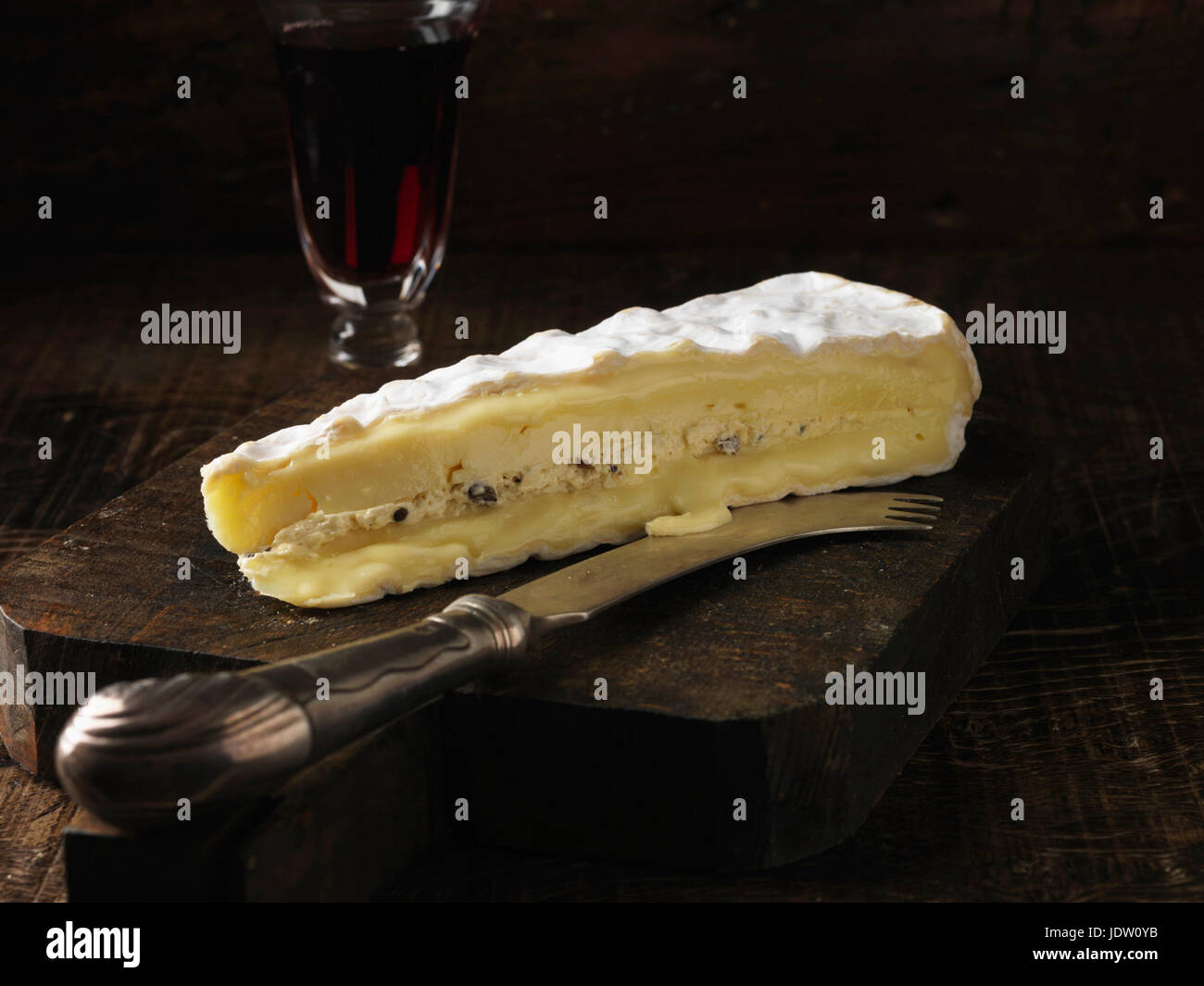 Slice of brie cheese on wooden board Stock Photo