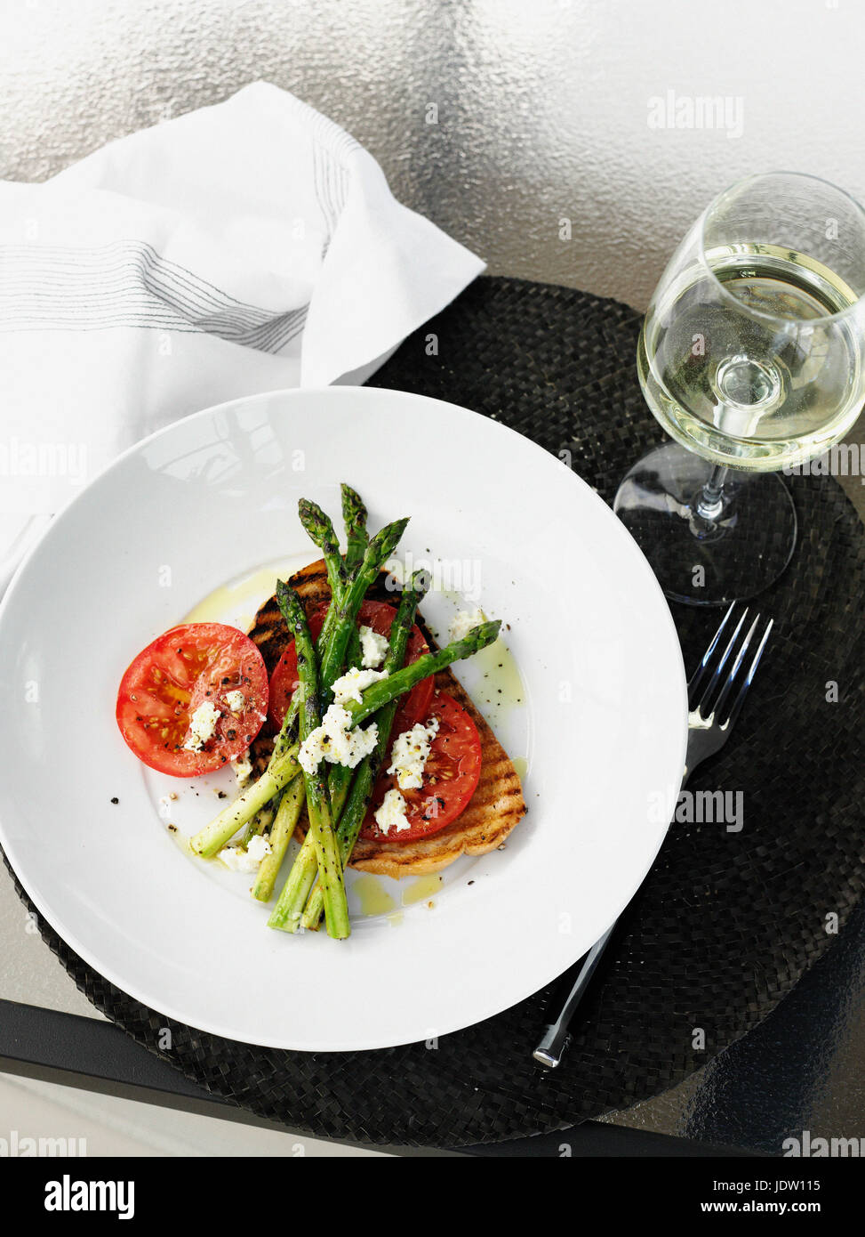 Plate of fish, asparagus and tomato Stock Photo