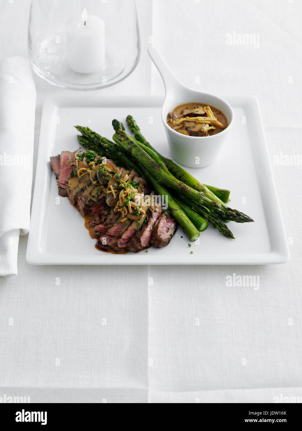 Plate of meat with asparagus and sauce Stock Photo