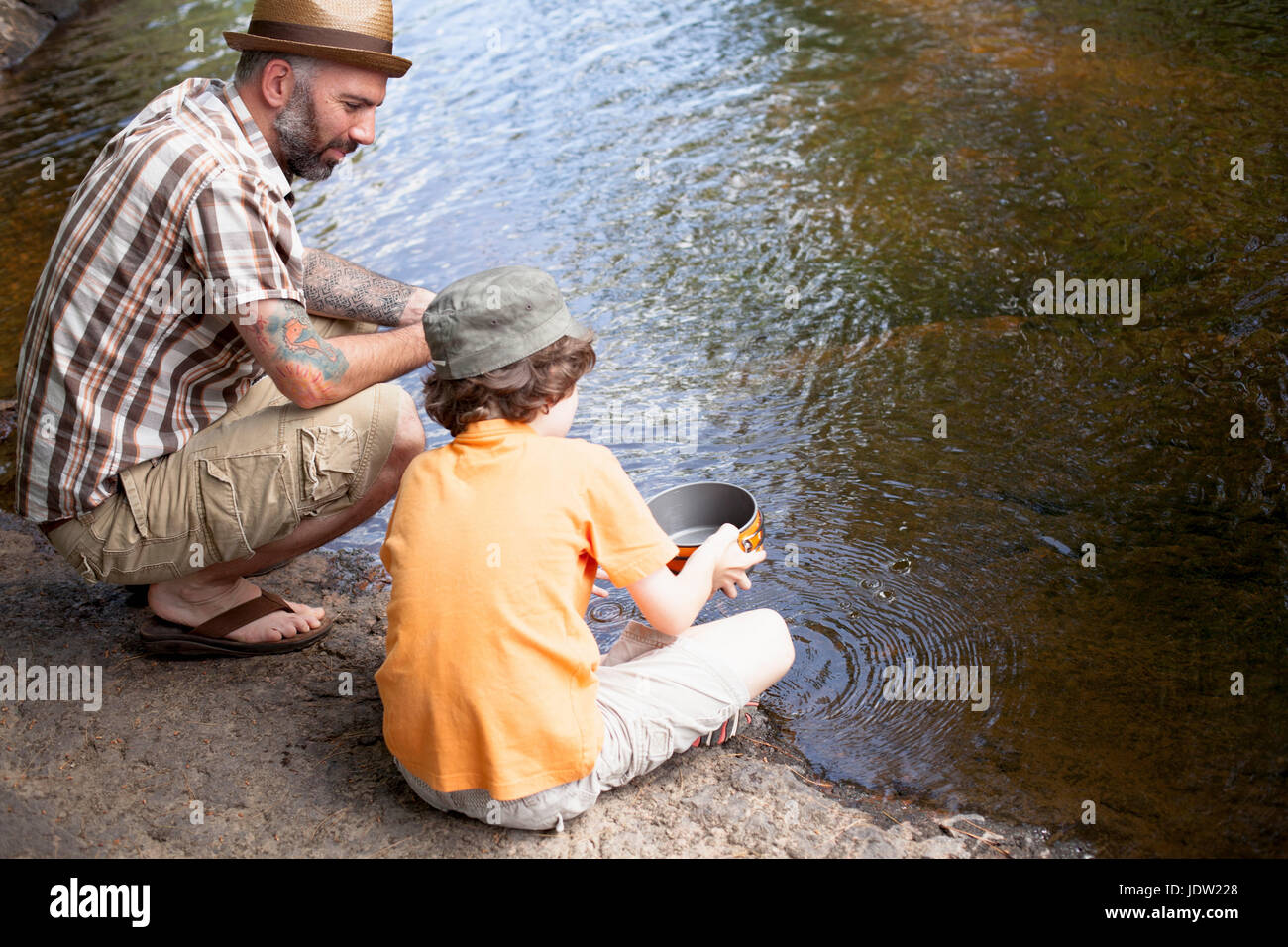 Father and son panning for gold in river Stock Photo