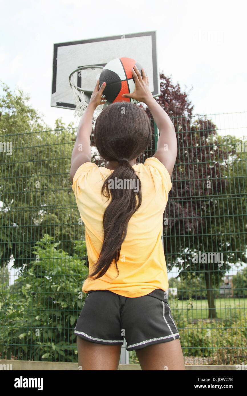 Woman shooting basketball on court Stock Photo Alamy