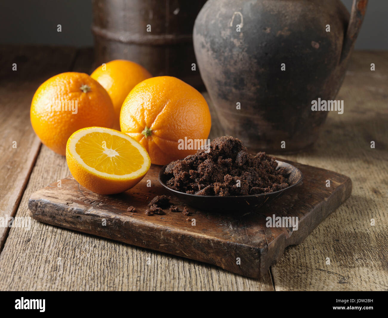 Plate of dark sugar and oranges Stock Photo