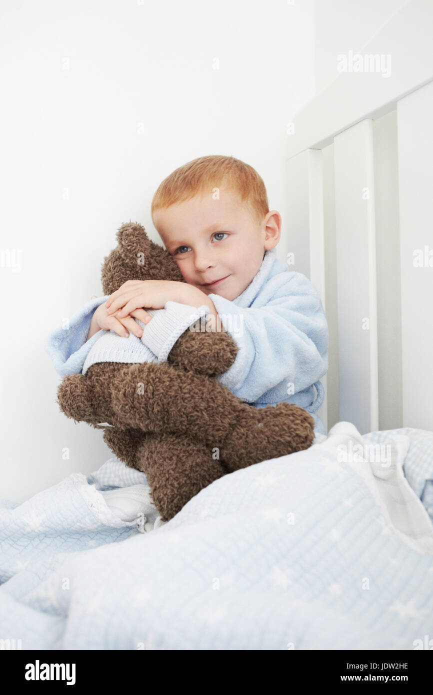 Boy hugging teddy bear in bed Stock Photo - Alamy