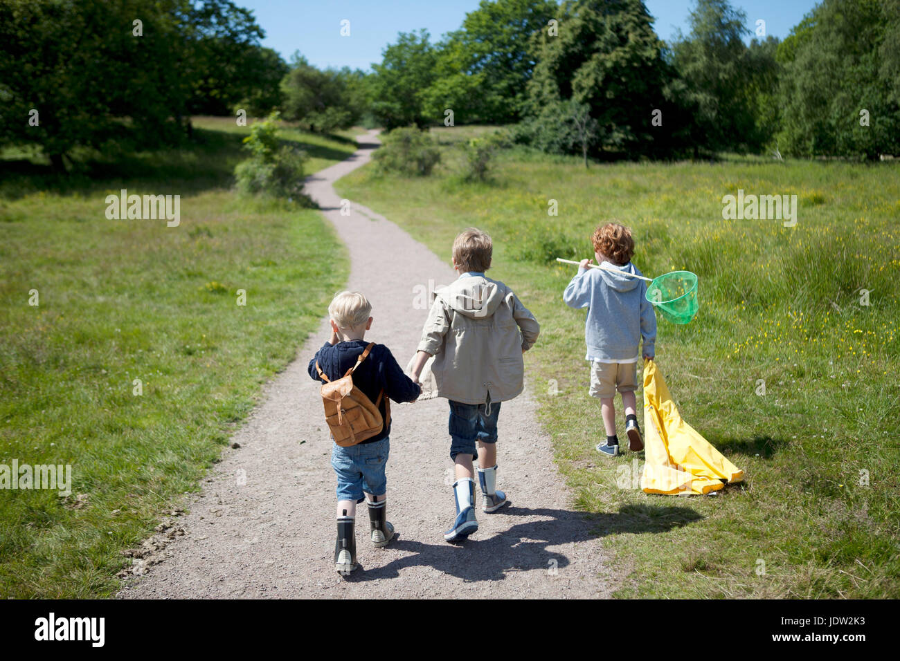 Children walking on dirt road Stock Photo