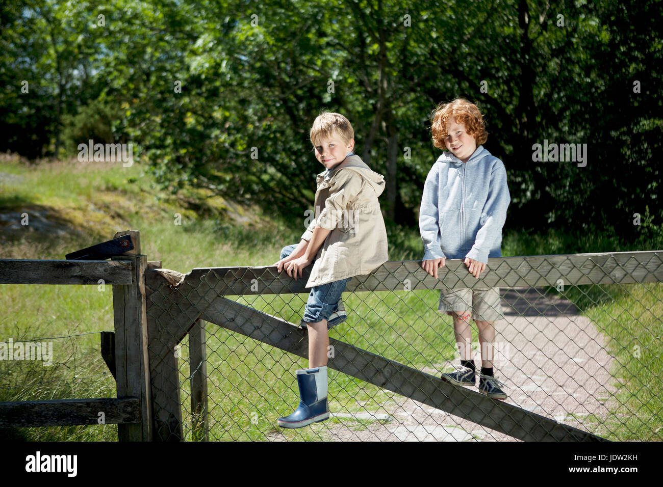 Children climbing wooden fence outdoors Stock Photo