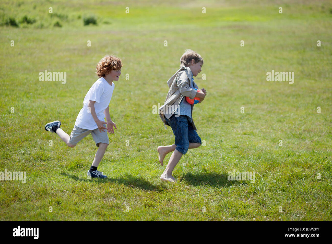 Children chasing each other outdoors Stock Photo