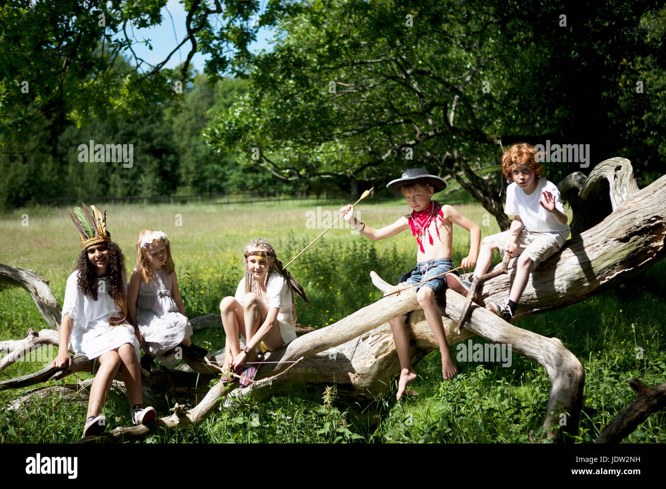 Children in costumes playing on tree Stock Photo