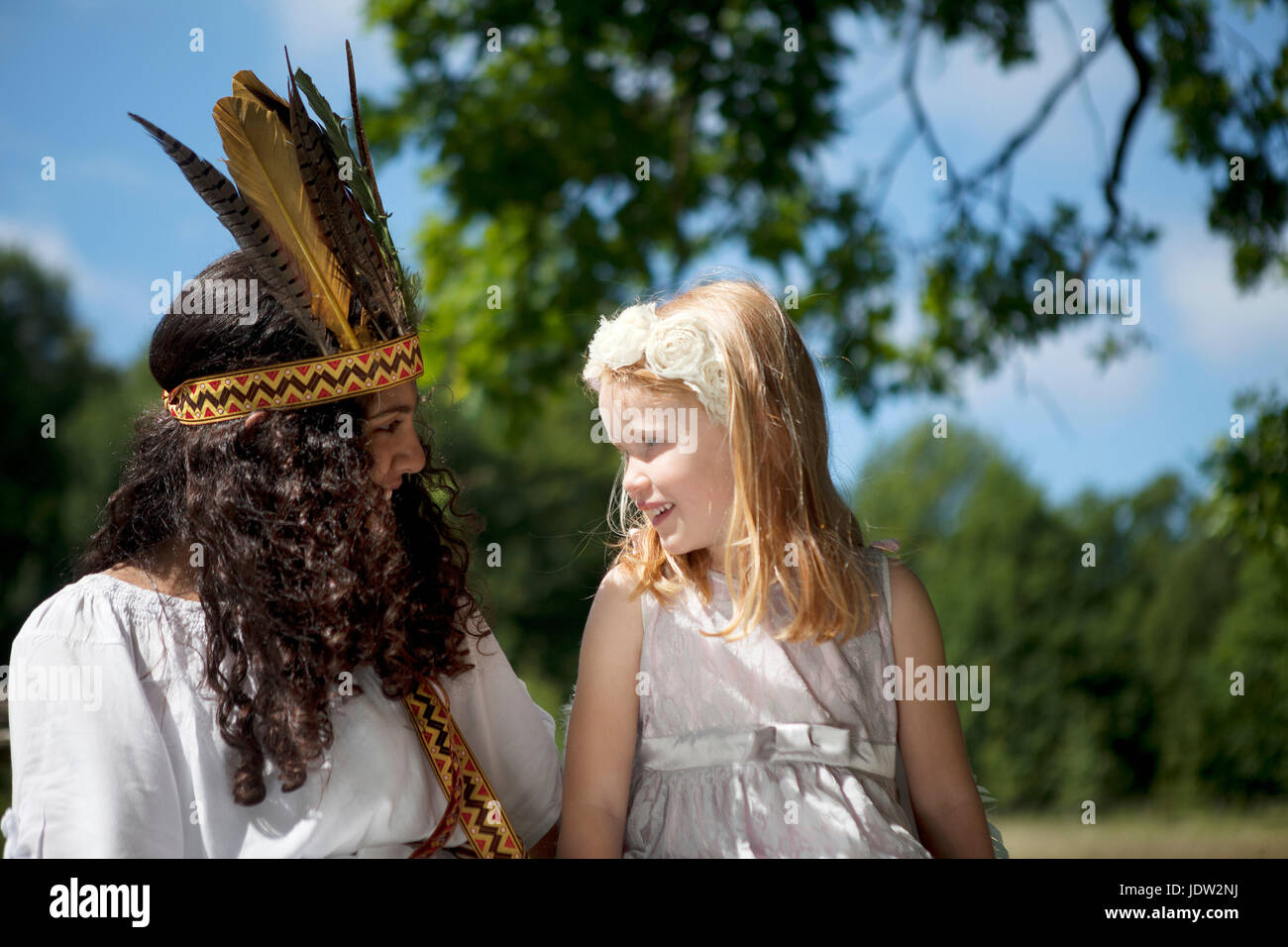 Girls in costumes sitting outdoors Stock Photo
