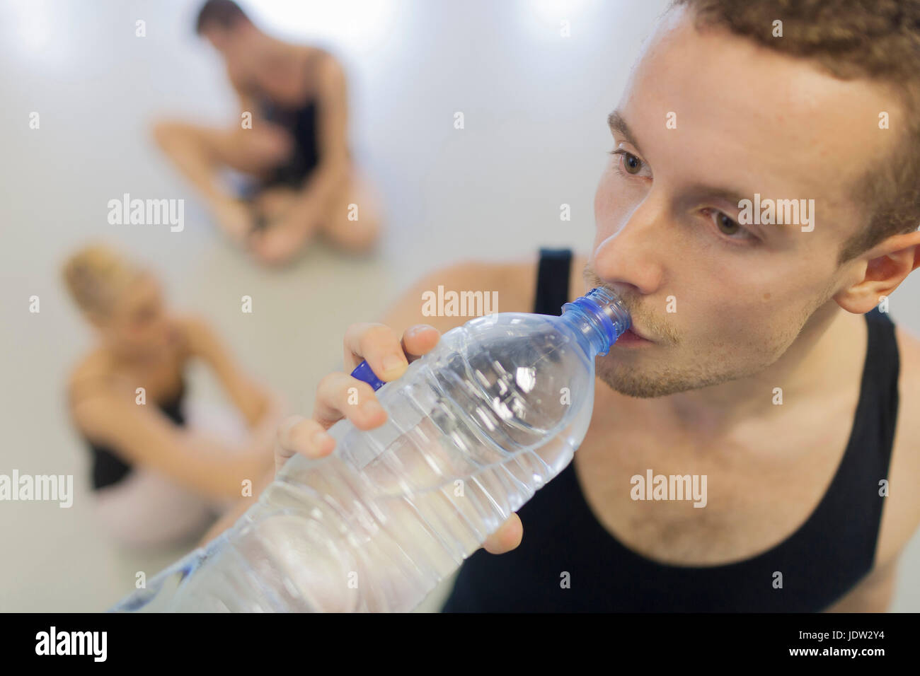 Dancer drinking water bottle in studio Stock Photo