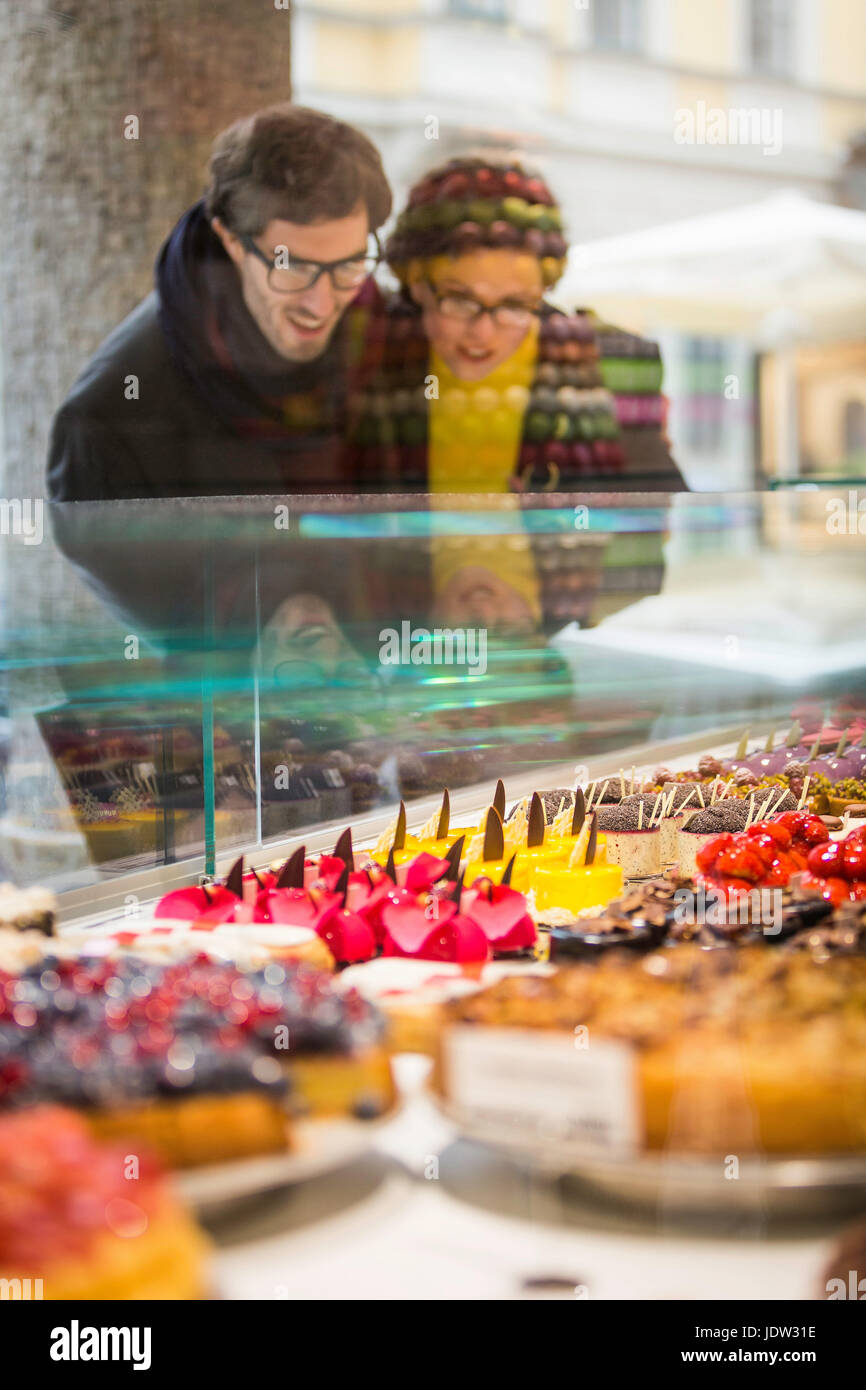 Couple admiring pastries in case Stock Photo