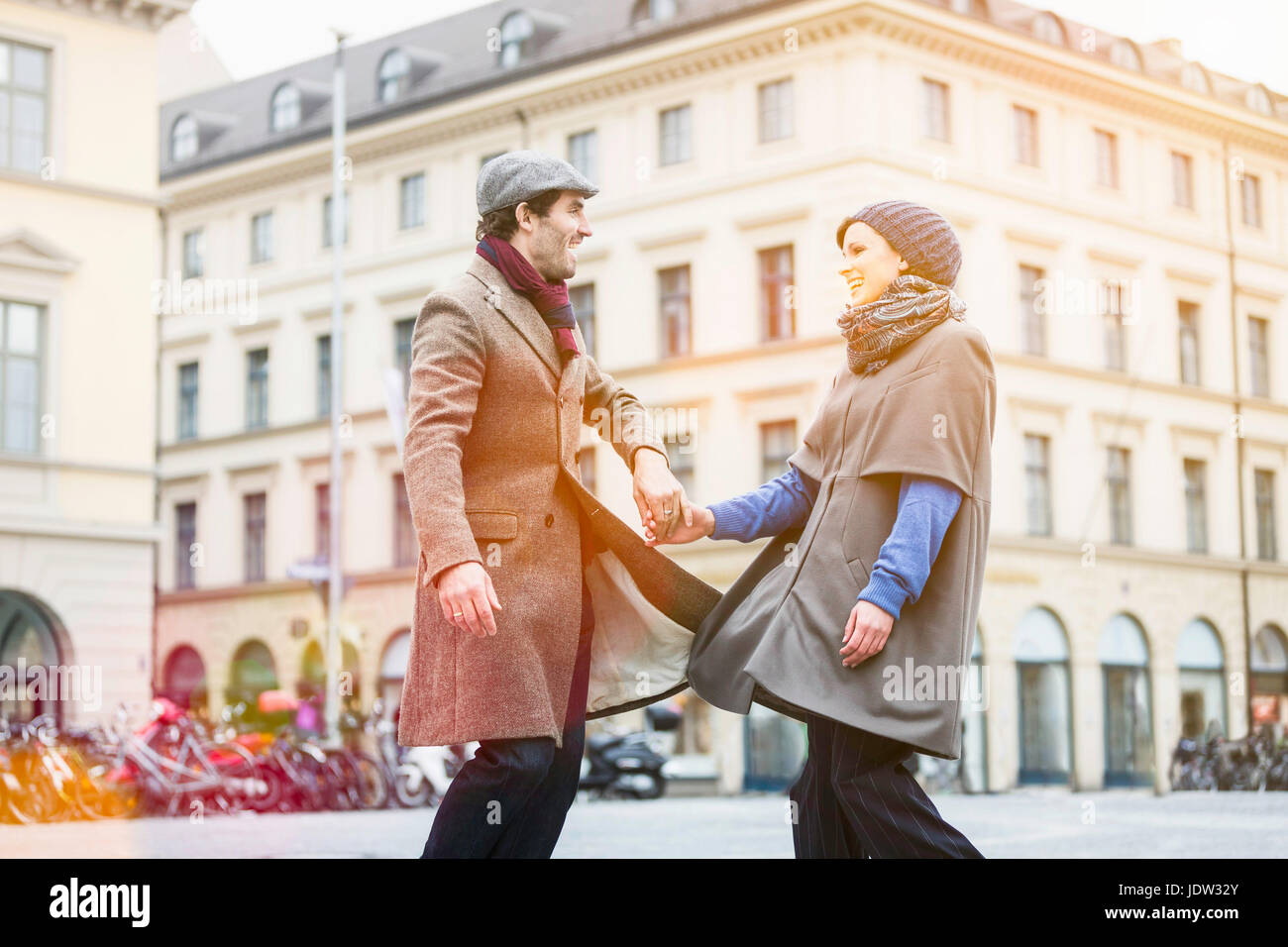 Couple holding hands on city street Stock Photo