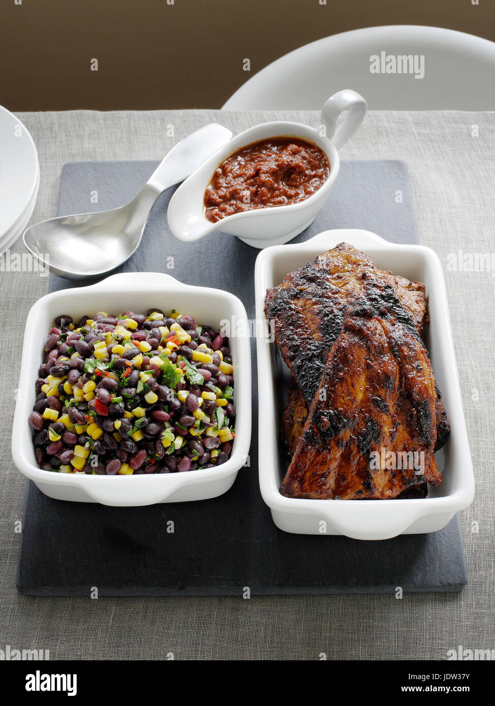 Dishes of pork ribs and black bean salad Stock Photo