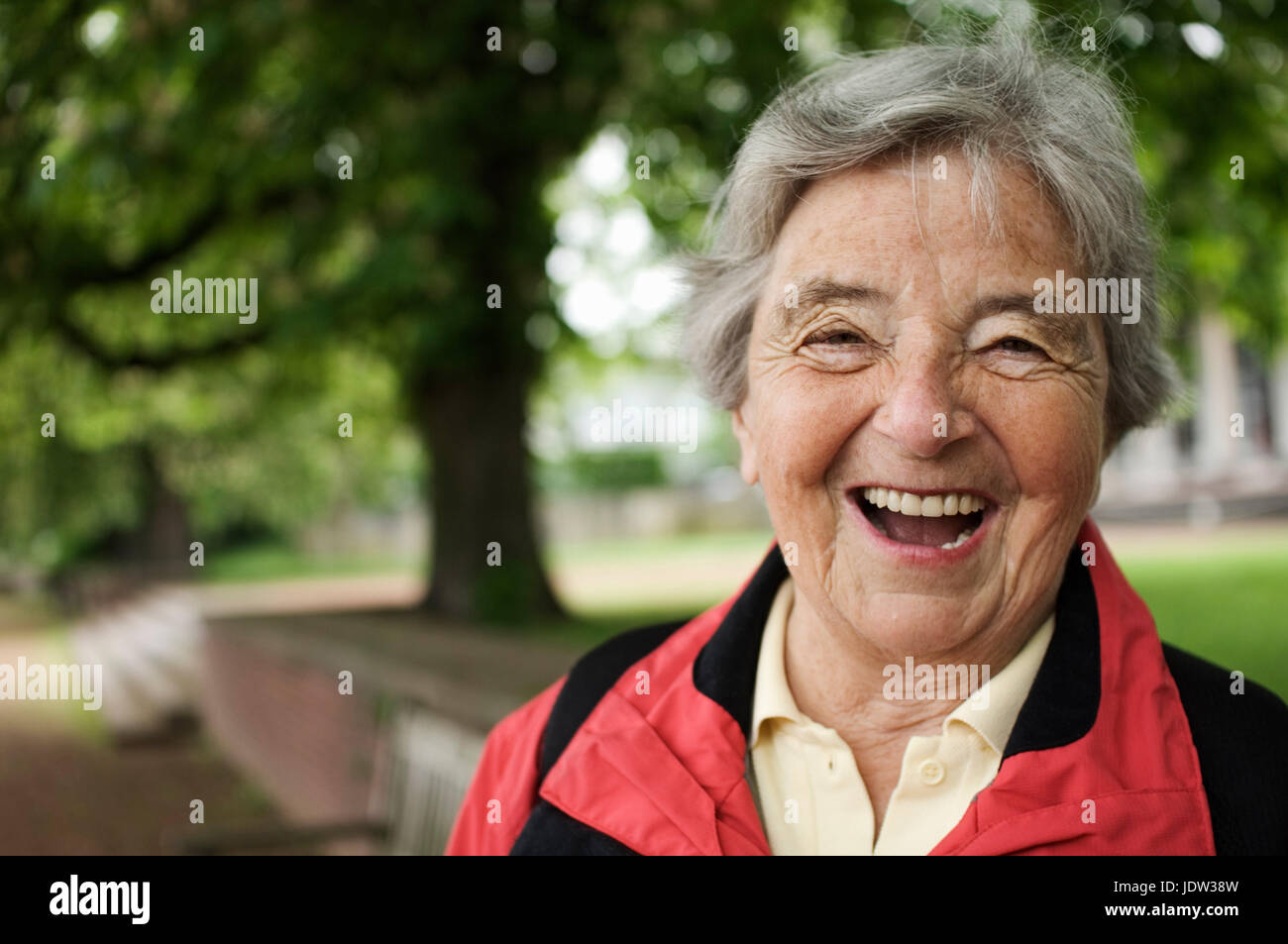 Older woman laughing in park Stock Photo