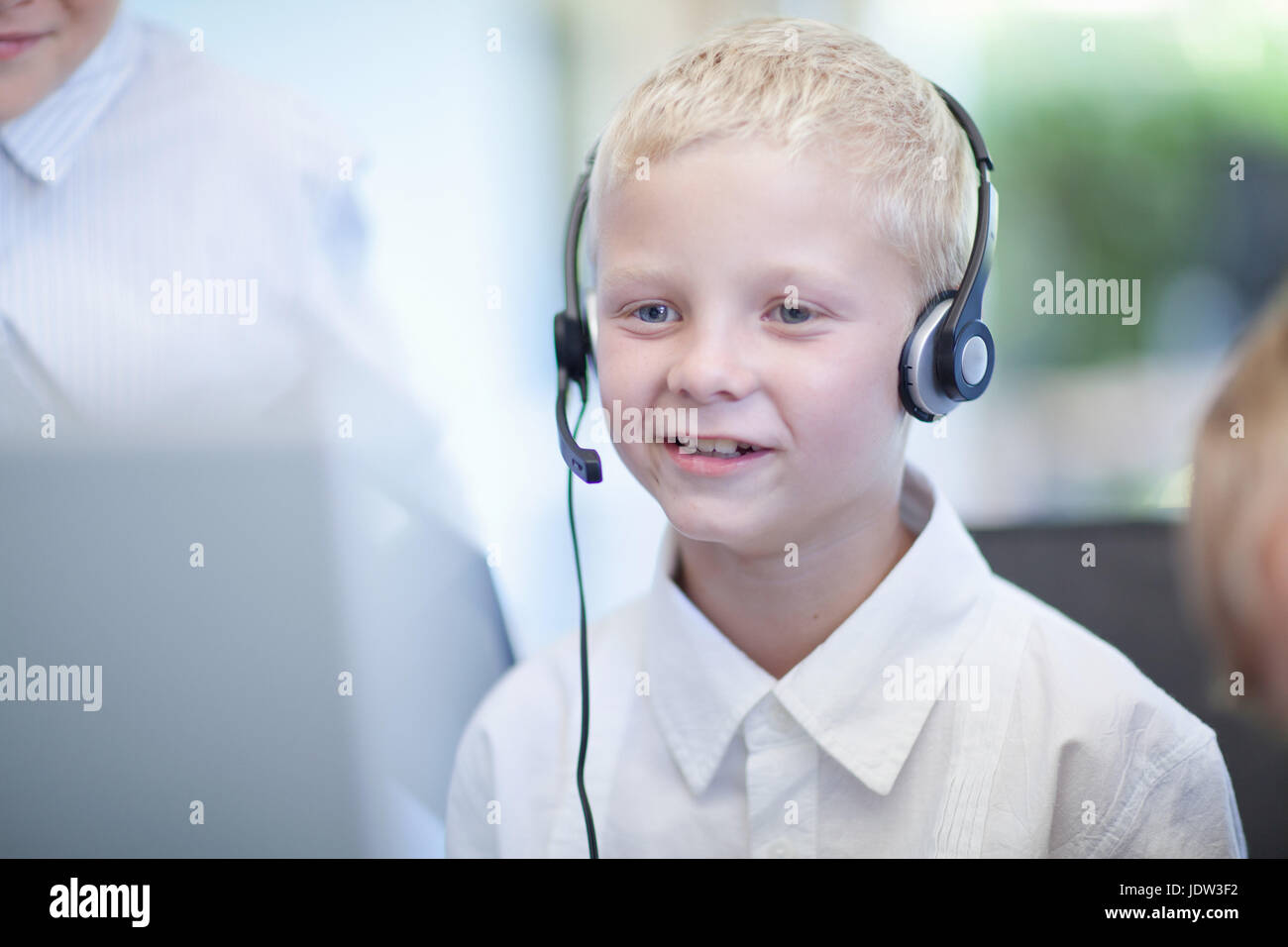 Boy playing businessman at desk Stock Photo