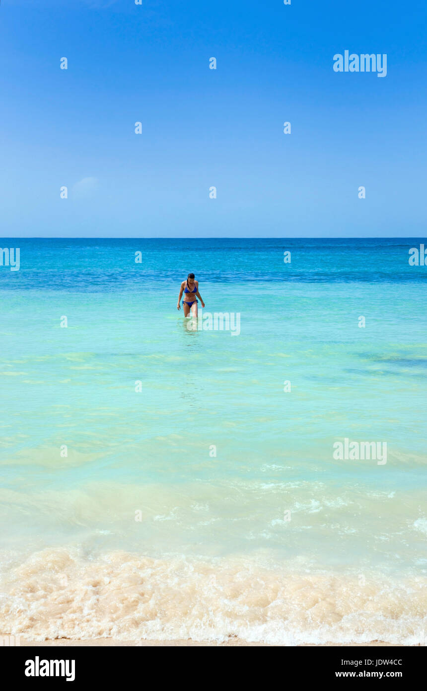 Woman in sea at beach in front of Dunn's River Falls, Jamaica Stock Photo