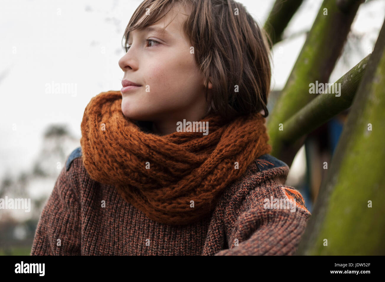 Boy in scarf looking away, outdoors Stock Photo