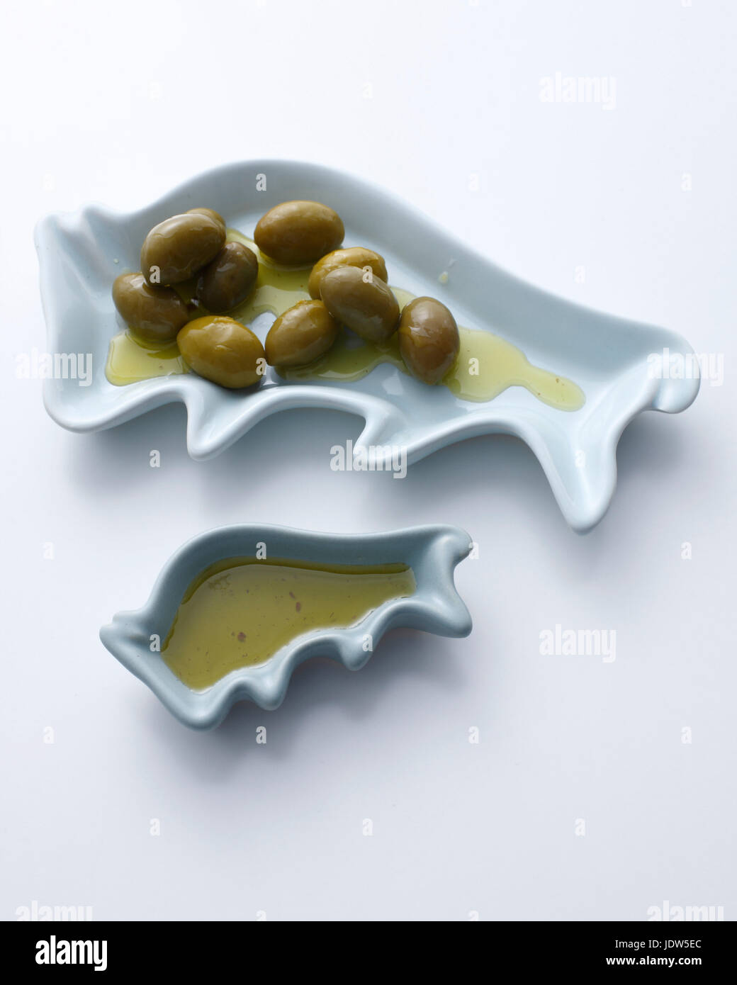 Green olives and olive oil in dishes Stock Photo Alamy