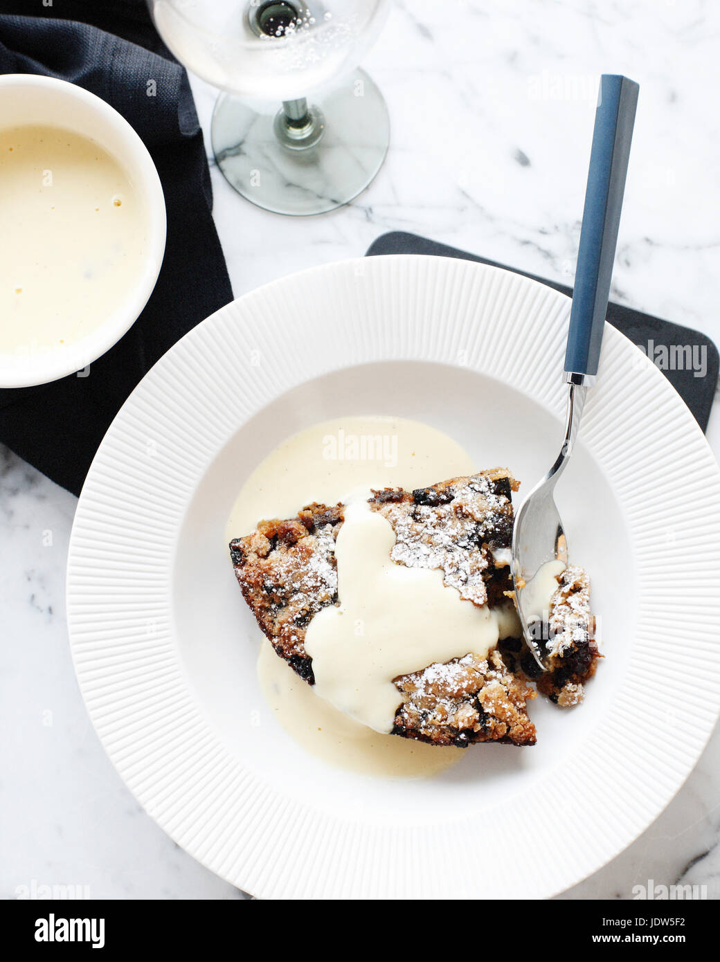 Bowl of bread and butter pudding with custard cream sauce Stock Photo