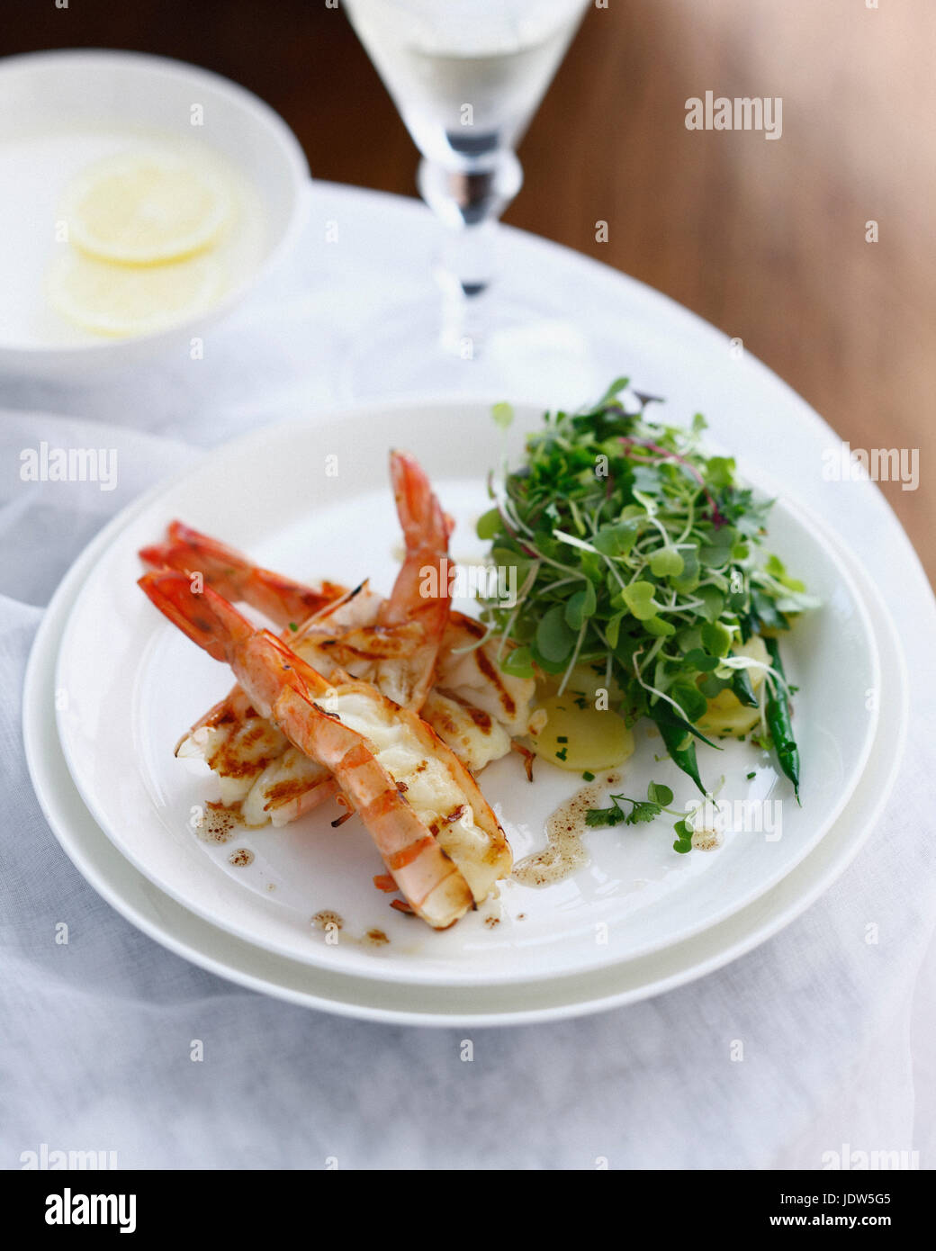 Plate of prawn salad with potatoes and micro herbs Stock Photo
