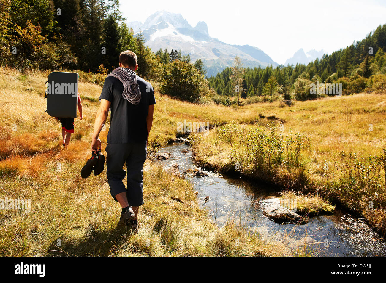 Two men hiking by stream, Chamonix, Haute Savoie, France Stock Photo