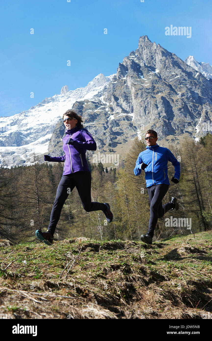 Mid adult couple running, Chamonix, France Stock Photo