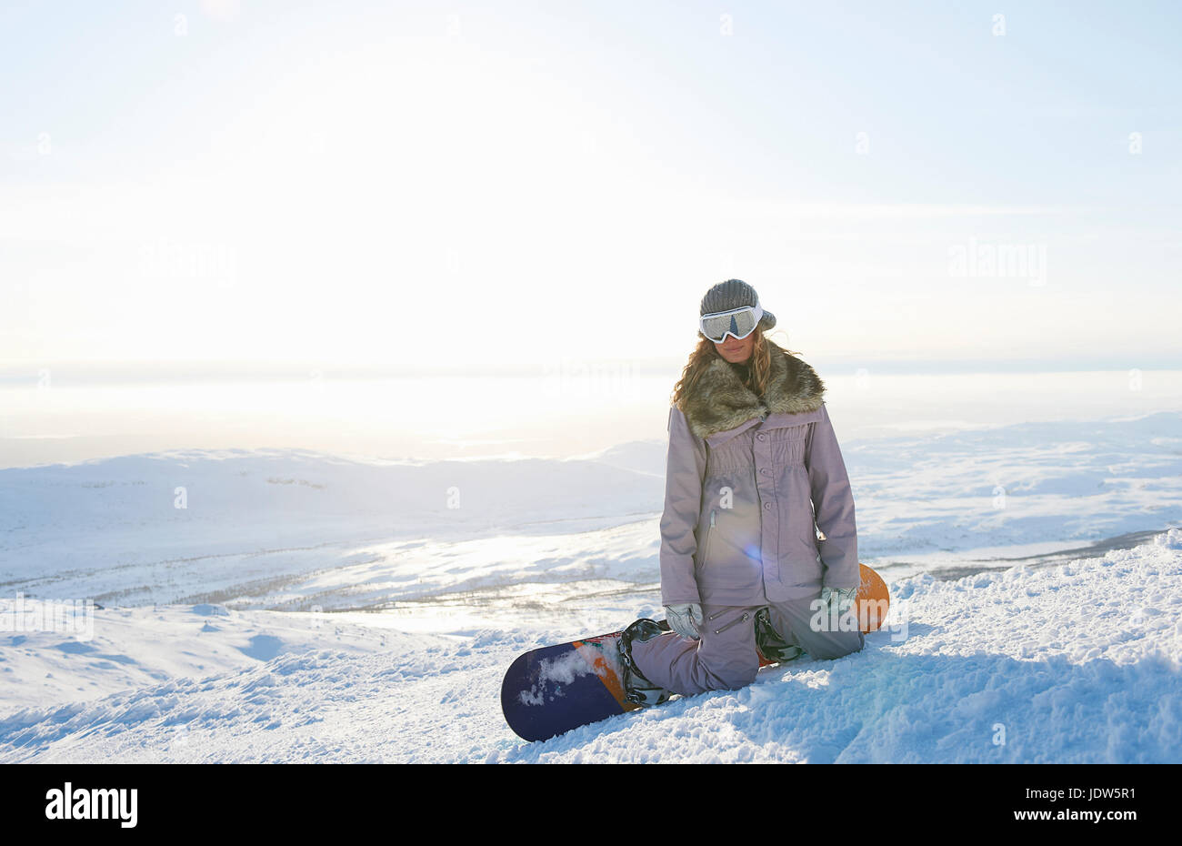 Snowboarder kneeling in snow, Are, Sweden Stock Photo