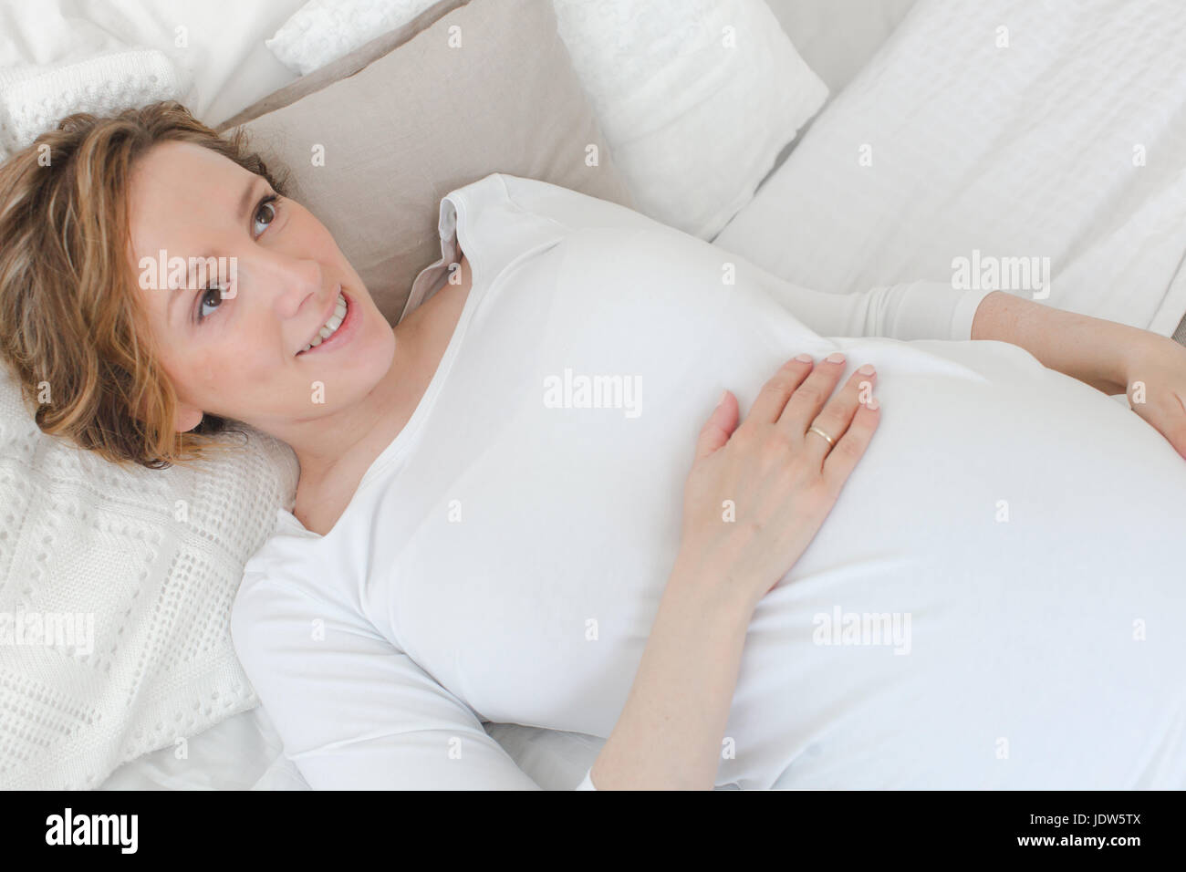 Pregnant woman lying on bed Stock Photo Alamy