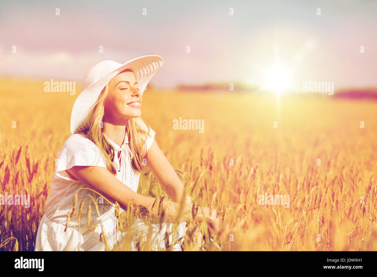 happy young woman in sun hat on cereal field Stock Photo - Alamy