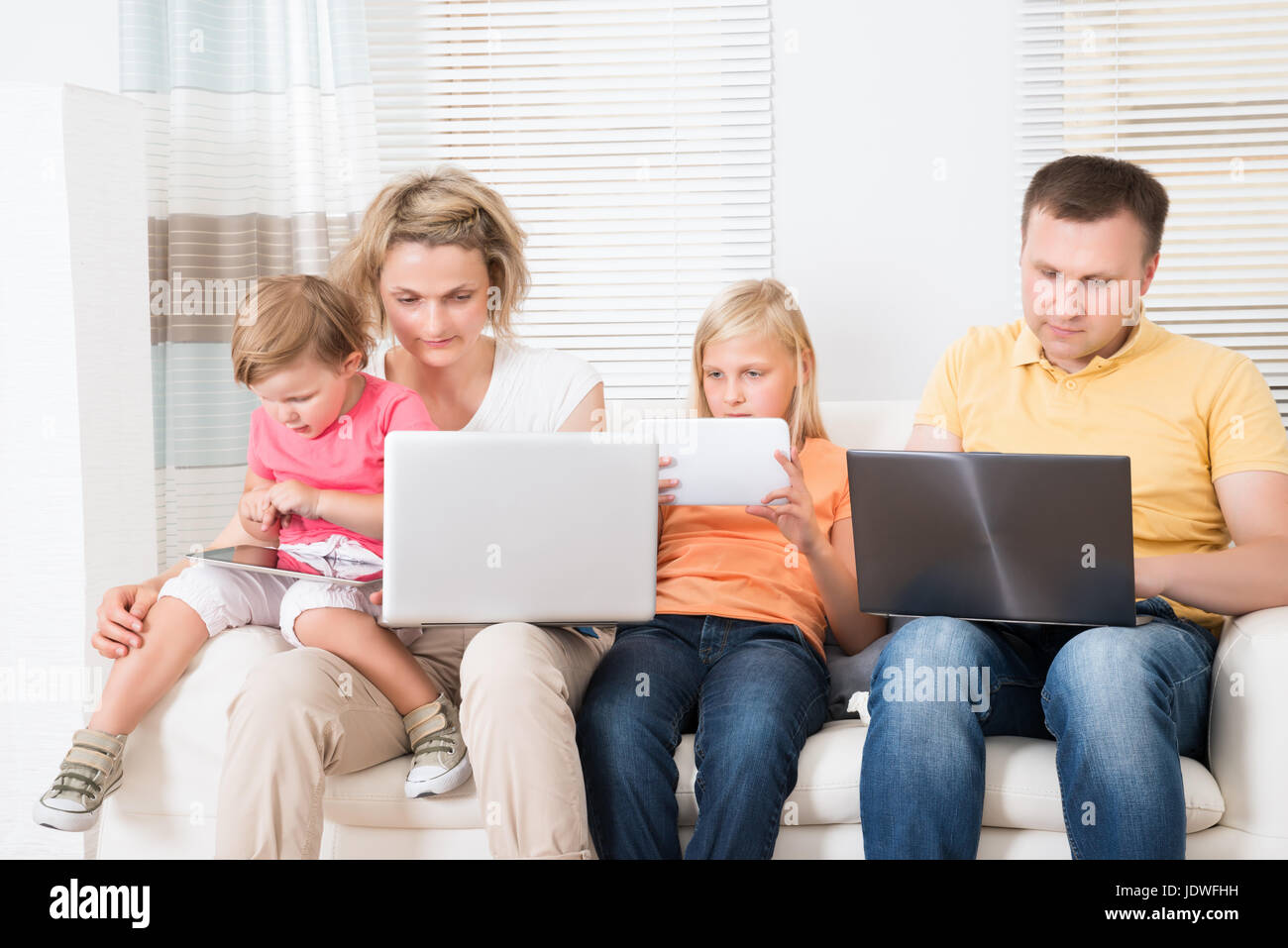 Family Using Tablets and Computers At Home Stock Photo - Alamy