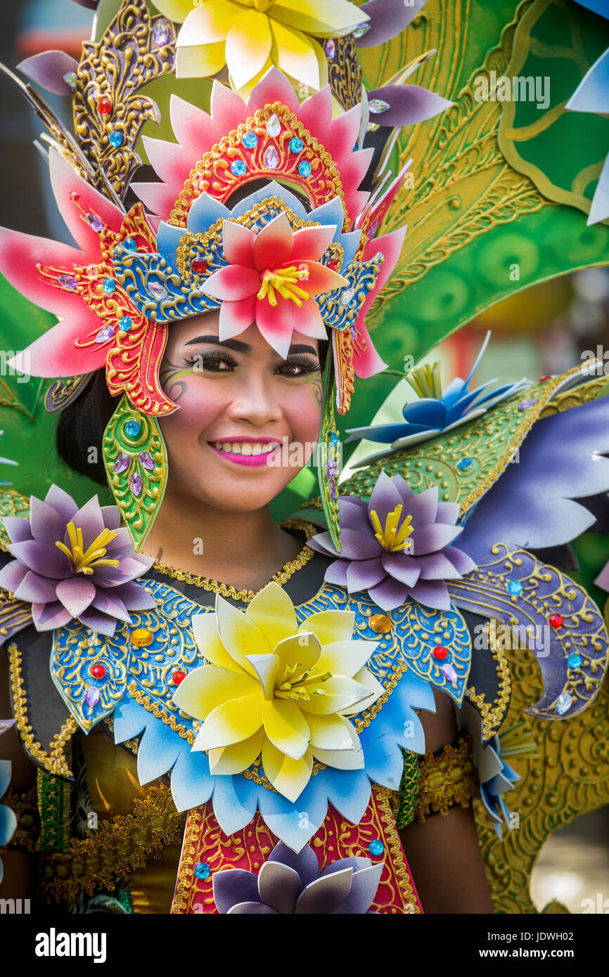 Vibrantly colored Carnival costume worn by a beautiful Balinese girl at the Bali Arts Festival on the opening day parade showcasing Balinese culture Stock Photo