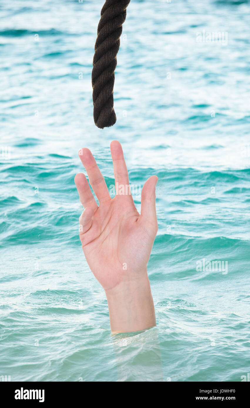 Man reaching for rope while drowning in water Stock Photo - Alamy