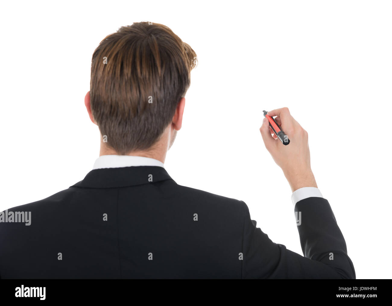 Rear view of young businessman writing with marker on white background ...