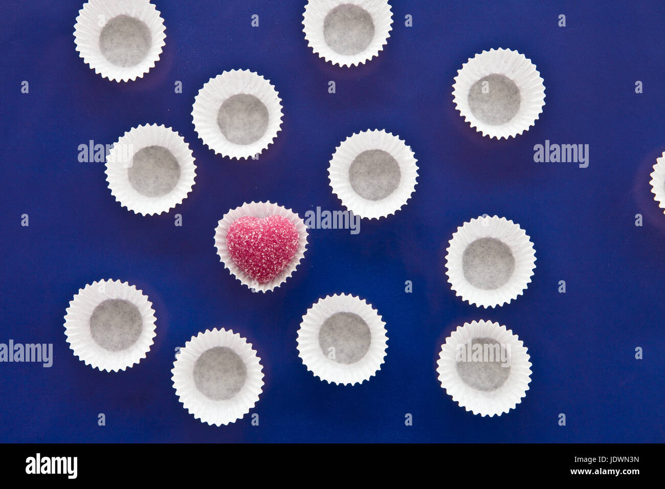 Rosa Herz Praline auf blauem Hintergrund mit Textfreiraum Stock Photo