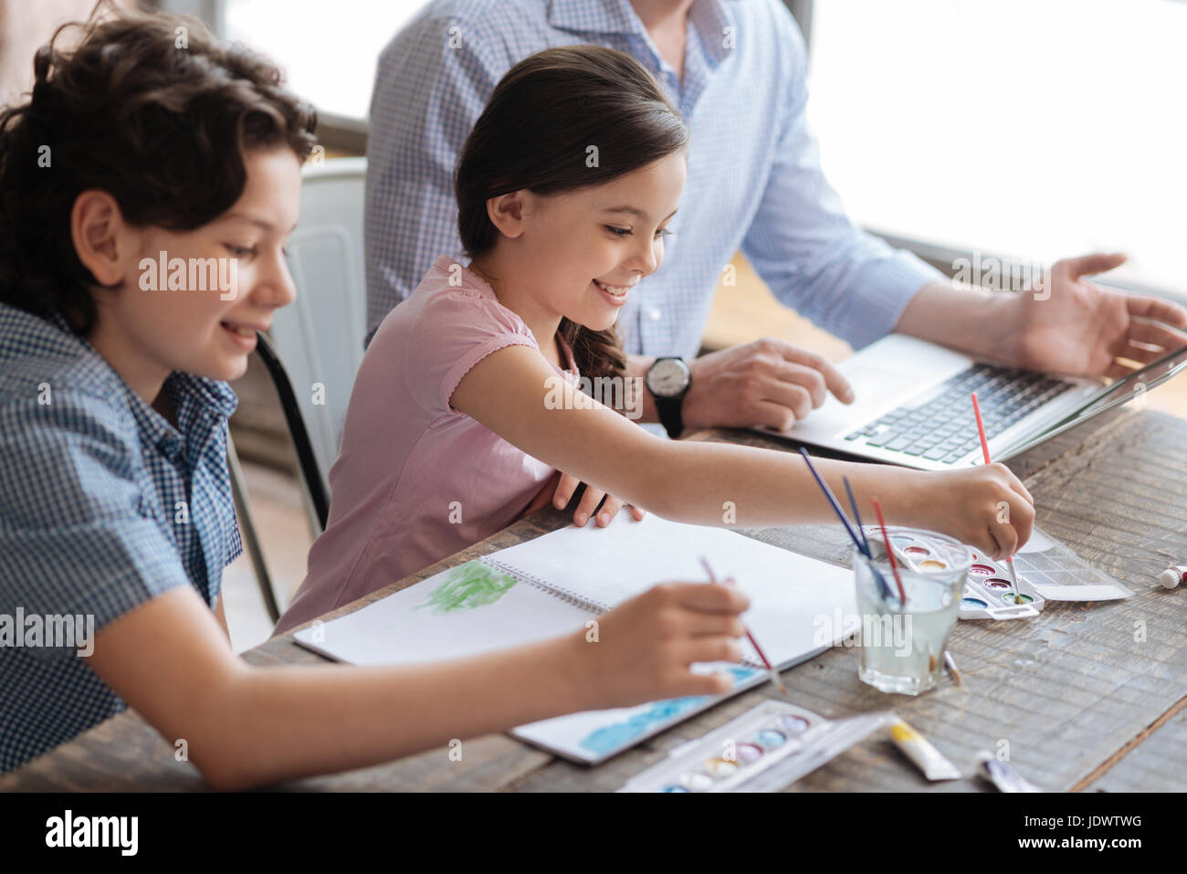 Gorgeous siblings painting with watercolors together Stock Photo - Alamy