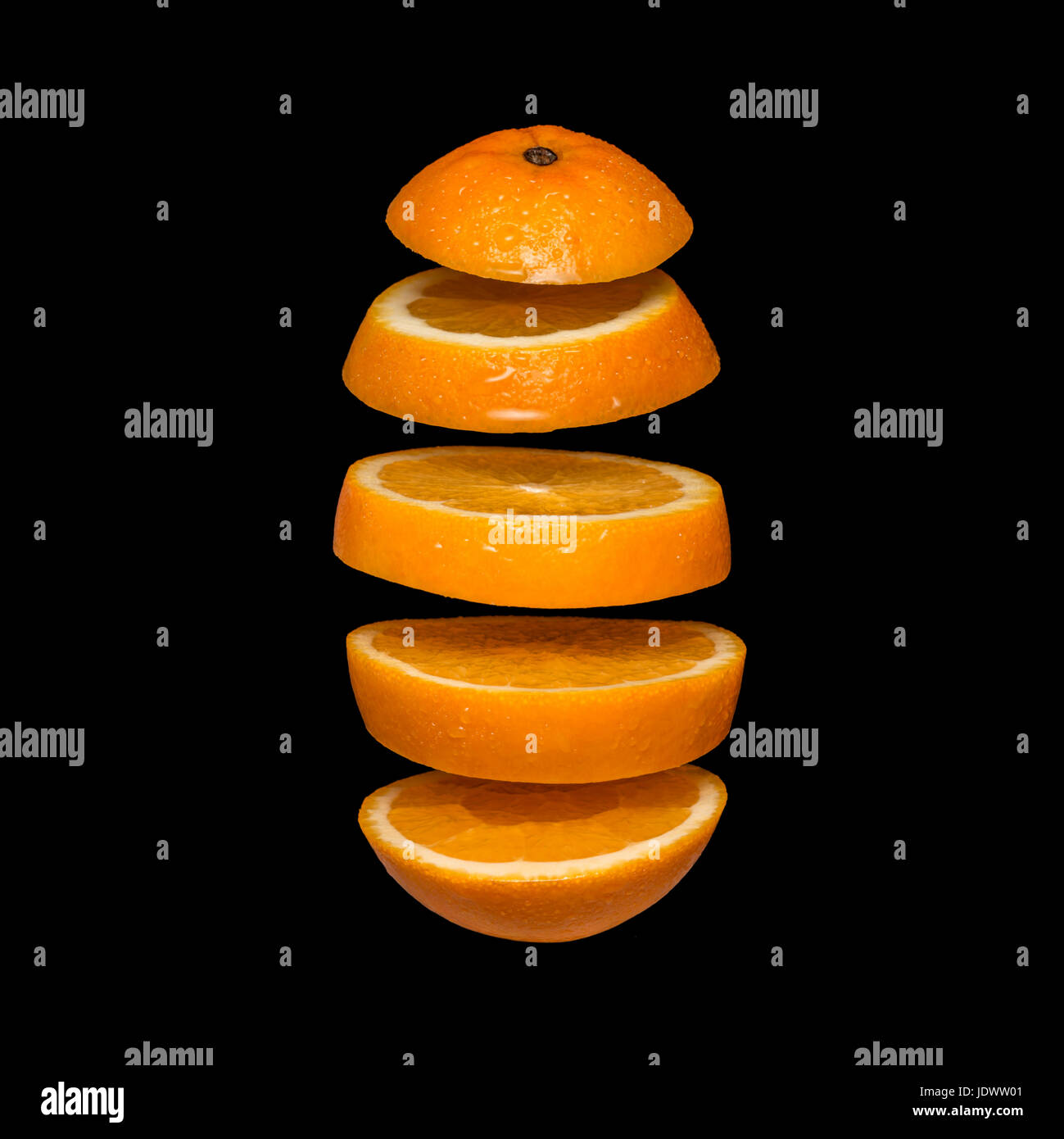 Creative concept with flying orange. Sliced orange isolated on black background. Levity fruit floating in the air Stock Photo