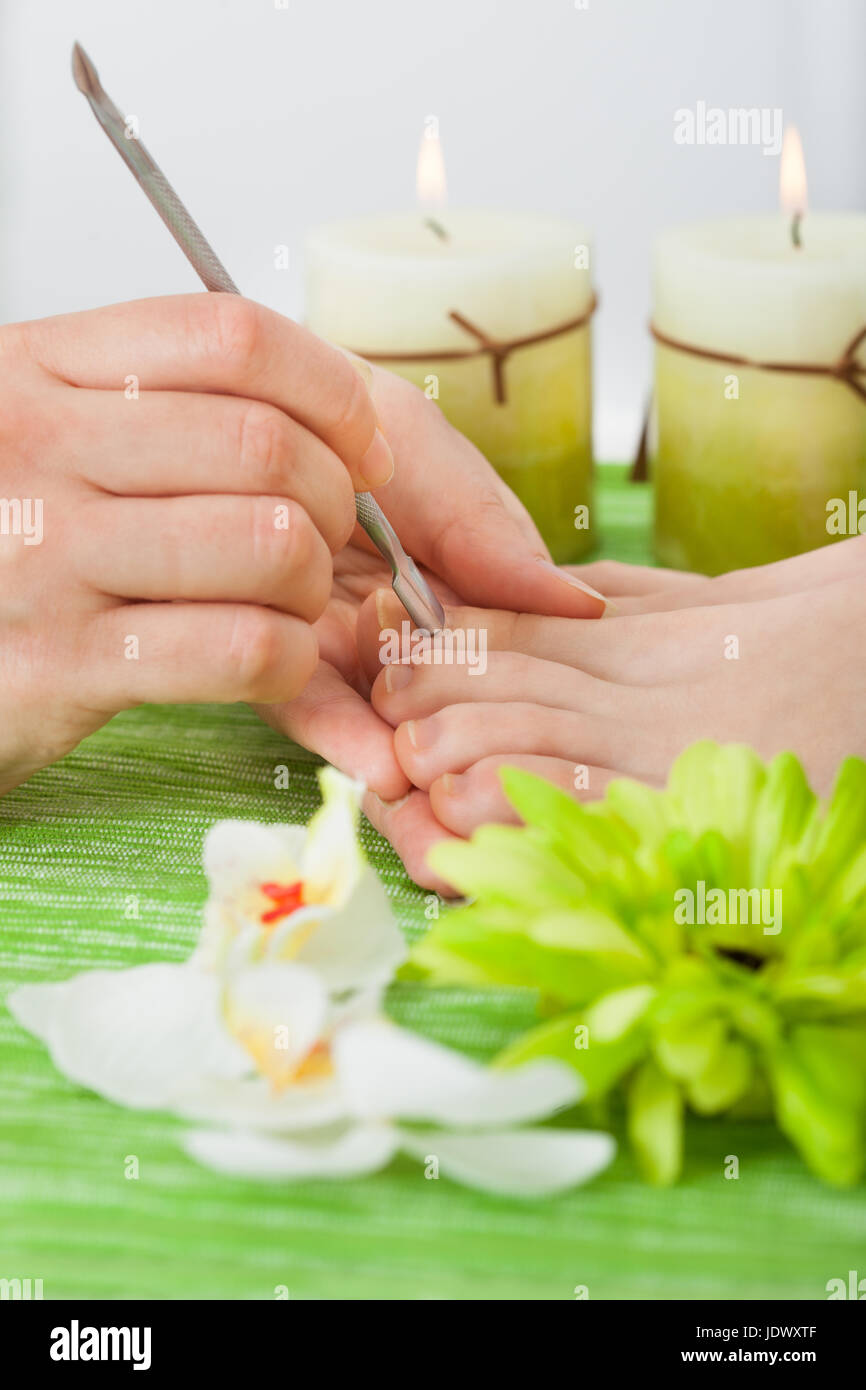 Closeup Of Beautician Hand Giving Pedicure Treatment To Woman's Nails