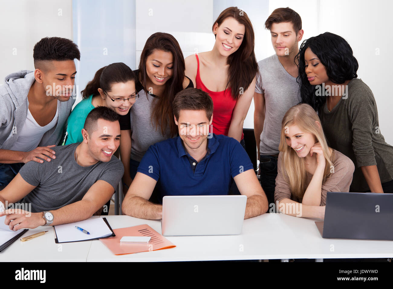 Group of multiethnic university students using laptop together in ...