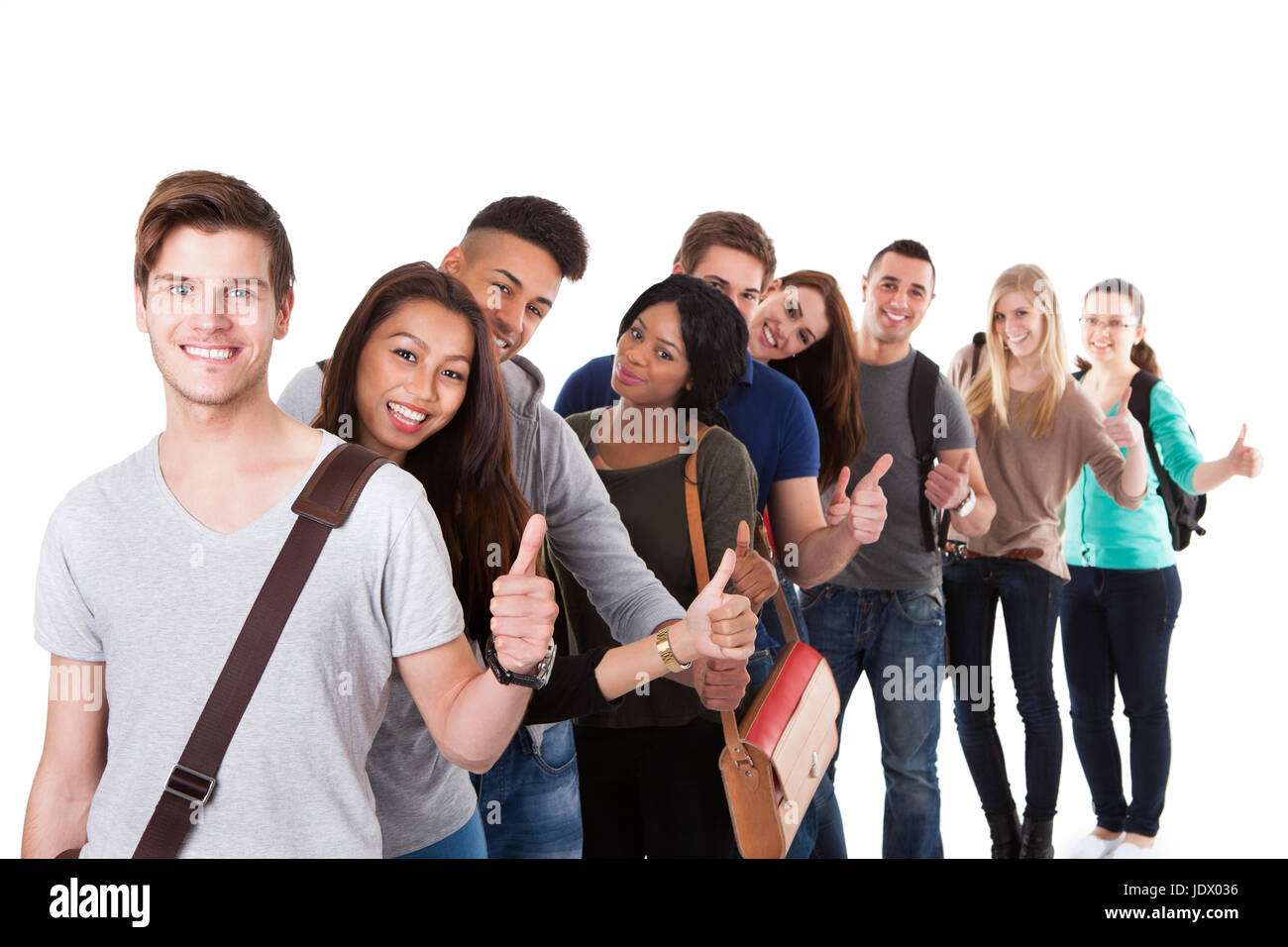 Portrait of college students gesturing thumbs up while standing in a ...