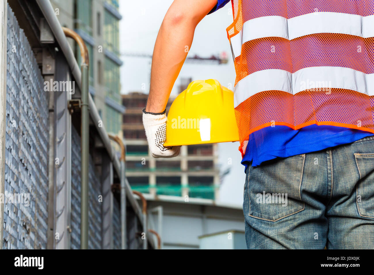 Worker on construction site with helmet or hard hat Stock Photo - Alamy