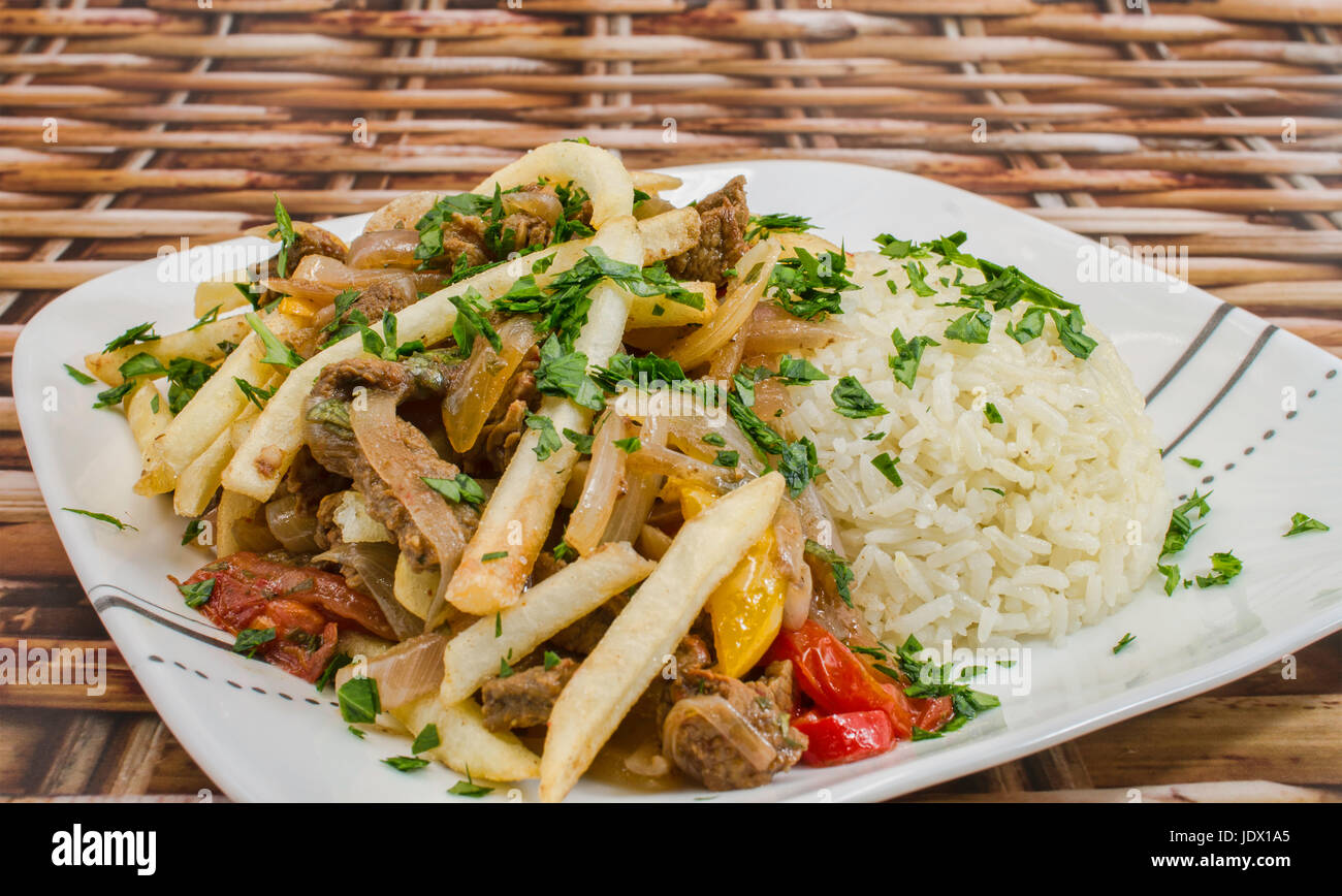 Lomo Saltado a Peruvian dish made with sautéed beef, tomatoes, onion, fried potatoes and rice. Stock Photo